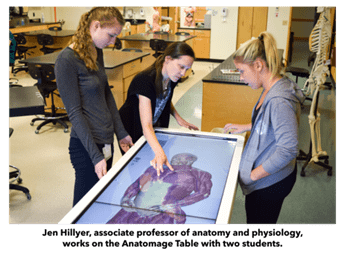 Professor and two students working on Anatomage Table with captions