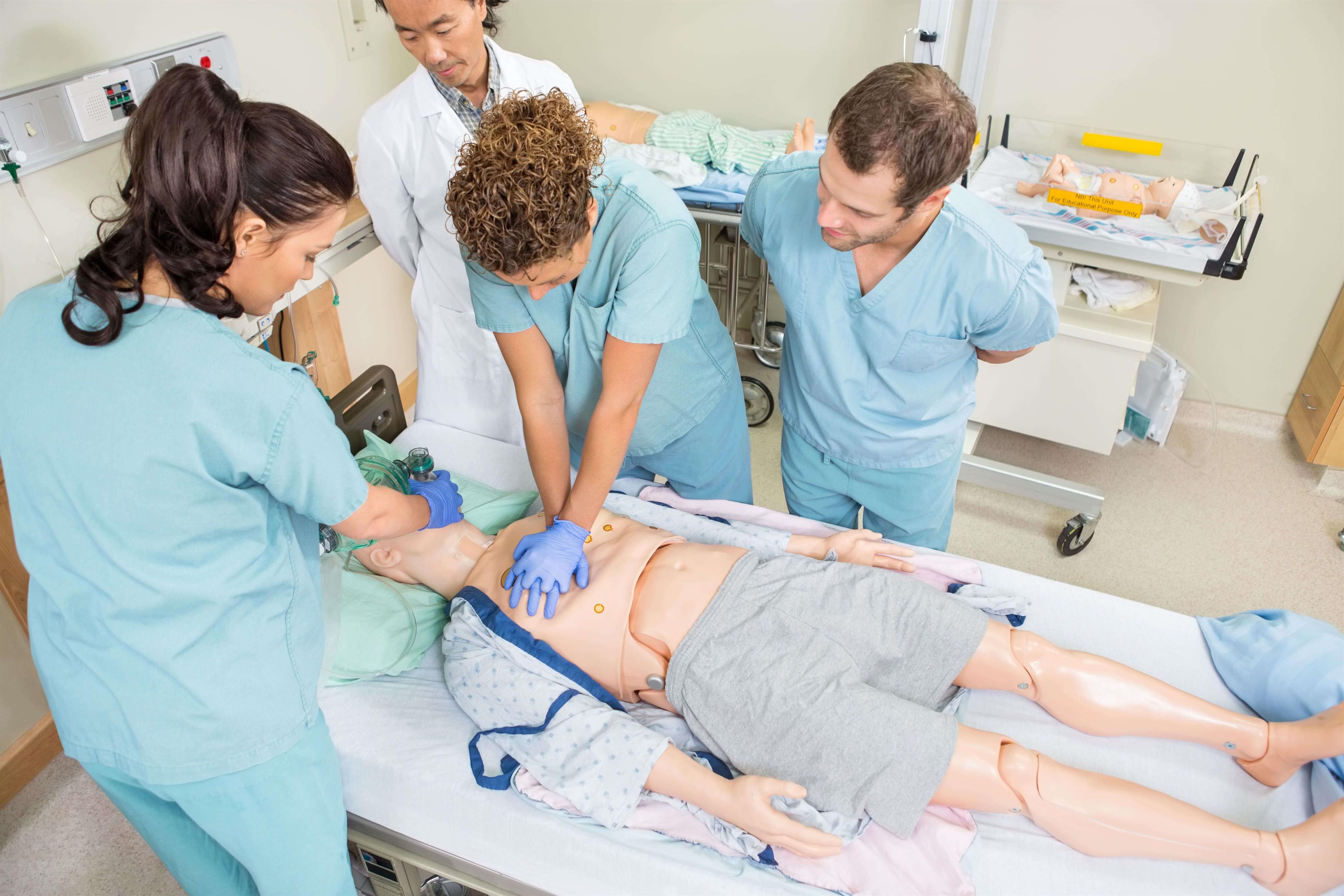 Nursing students performing CPR on a patient dummy